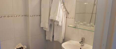 A bathroom with a bathtub, a sink, and a glass shower enclosure.