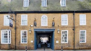 A traditional brick building with a central entrance, multiple windows, and a tiled roof. - Saracens Head Towcester by Greene King Inns (Towcester)