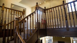 A wooden staircase with a handrail and balusters, leading to an upper floor. - Saracens Head Towcester by Greene King Inns (Towcester)