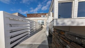 A narrow pathway leading to a building with a white fence on one side and a stone wall on the other. - Castletown Hotel (Thurso)