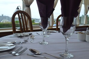 A table set for dining with wine glasses and cutlery. - Park Hotel (Thurso)