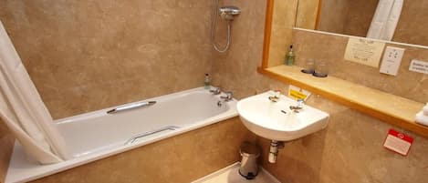 Un baño con bañera, lavamanos, inodoro y ducha.