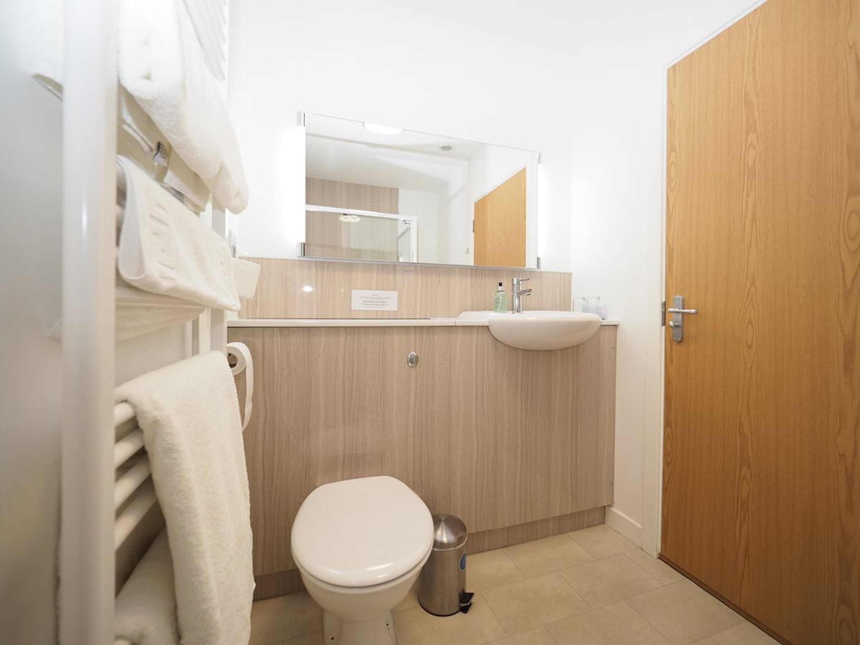 A modern bathroom with a toilet, sink, and mirror.