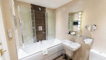 A modern bathroom with a glass-enclosed shower, a large bathtub, a sink, and a toilet.