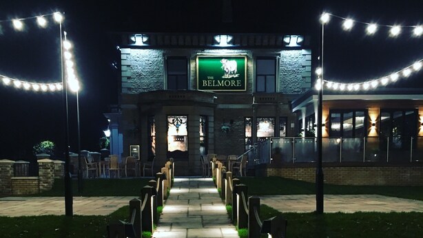 A pathway leading to a building with a sign reading "THE BELMORE." - Belmore (Sale)