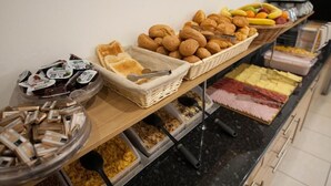 A buffet with various food items including pastries, fruits, and condiments. - St. George' s Inn Victoria (London)