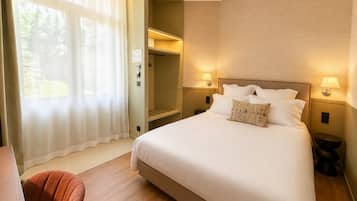 Habitación de hotel con una cama grande, dos lámparas de noche, un escritorio y una silla.