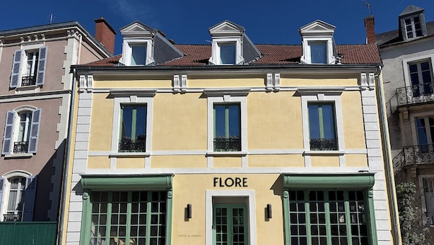 Un edificio con el letrero 'FLORE HOTEL & GARDIN' en la entrada.