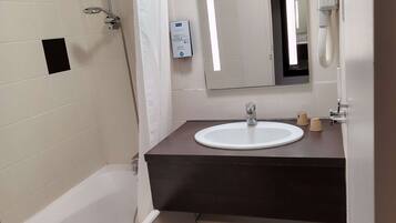 A bathroom with a bathtub, a sink, a mirror, and a shower.