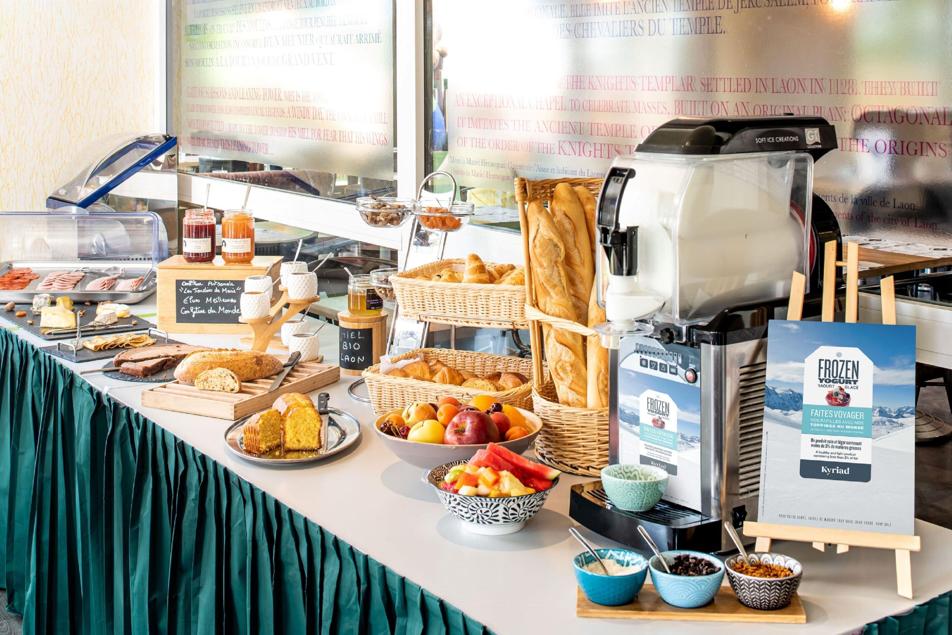 Un buffet de petit-déjeuner proposant une variété d’aliments, notamment du pain, des viennoiseries, des fruits et des boissons.
