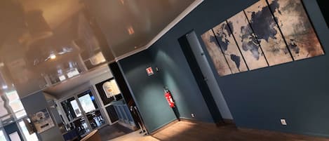 A modern interior with a wooden floor, a racing car model, and a world map artwork on the wall.