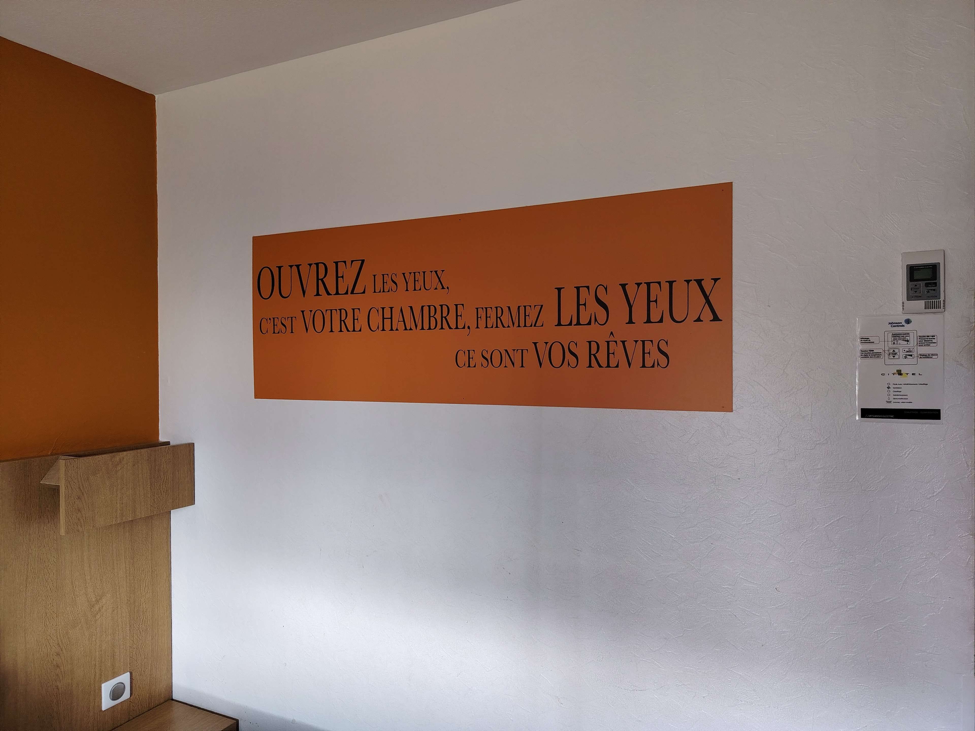 A wall with a sign in French.