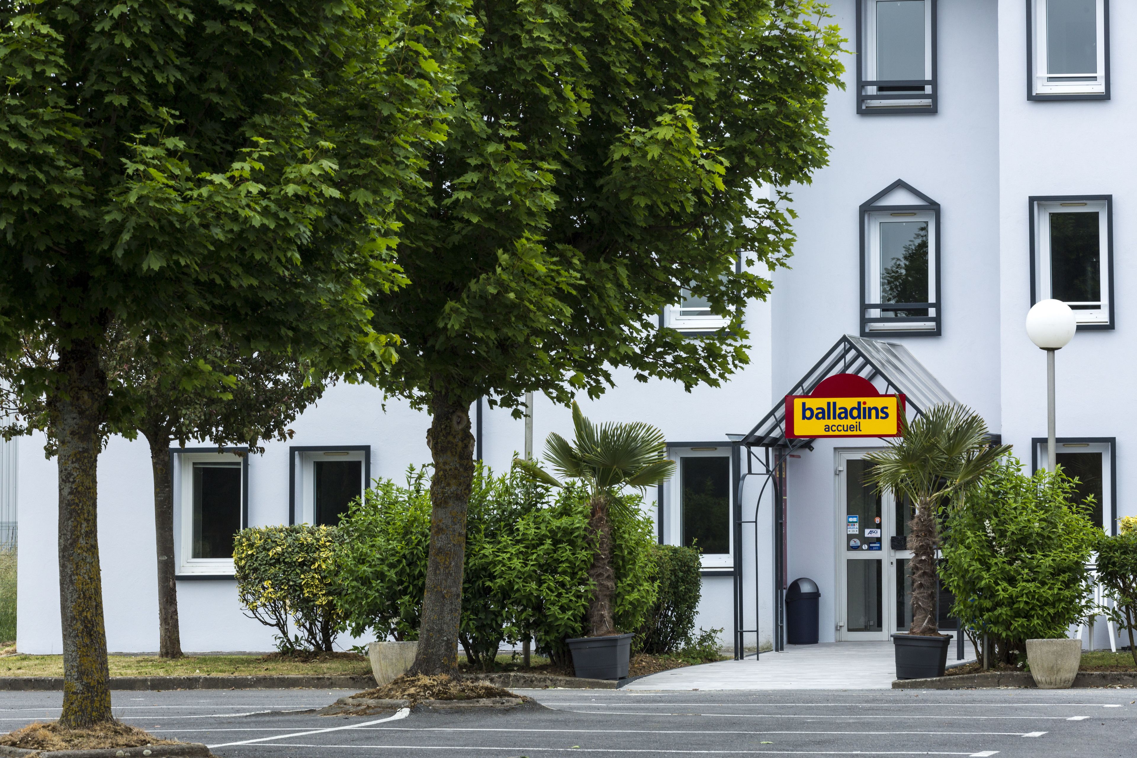 A hotel entrance with a sign reading "balladins accueil".