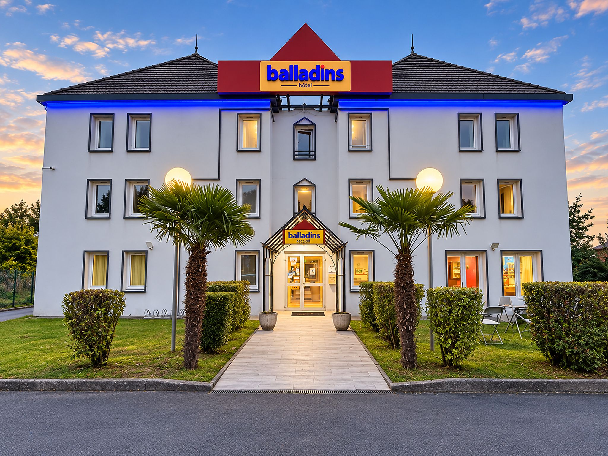 Un hôtel doté d’une entrée principale, de nombreuses fenêtres et d’une enseigne indiquant qu’il s’agit d’un hôtel Balladins.