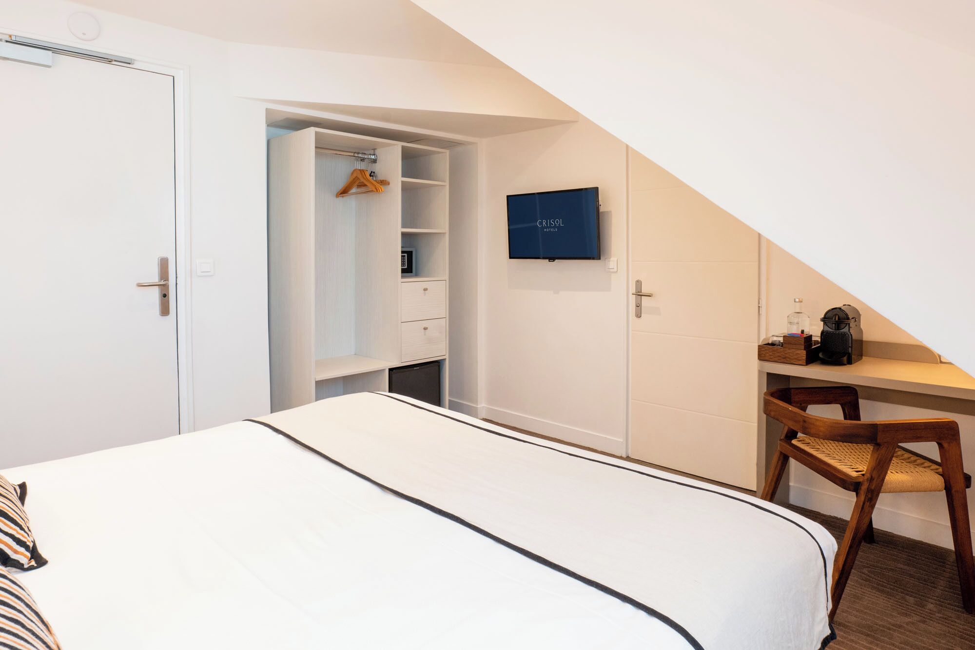Une chambre à coucher avec un lit, un bureau, une chaise, une armoire et un téléviseur.