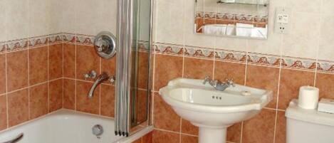 Un baño con bañera, lavamanos, inodoro y ducha.