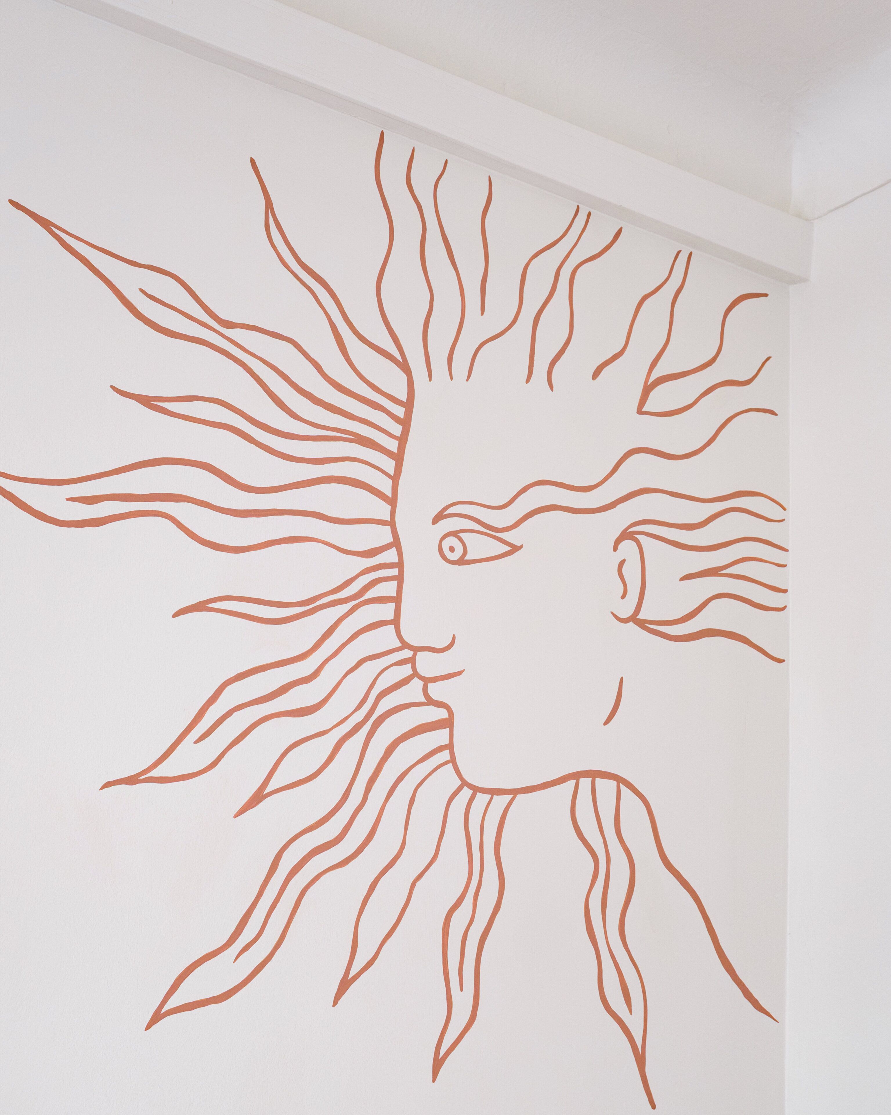 A wall with a sun-like design.