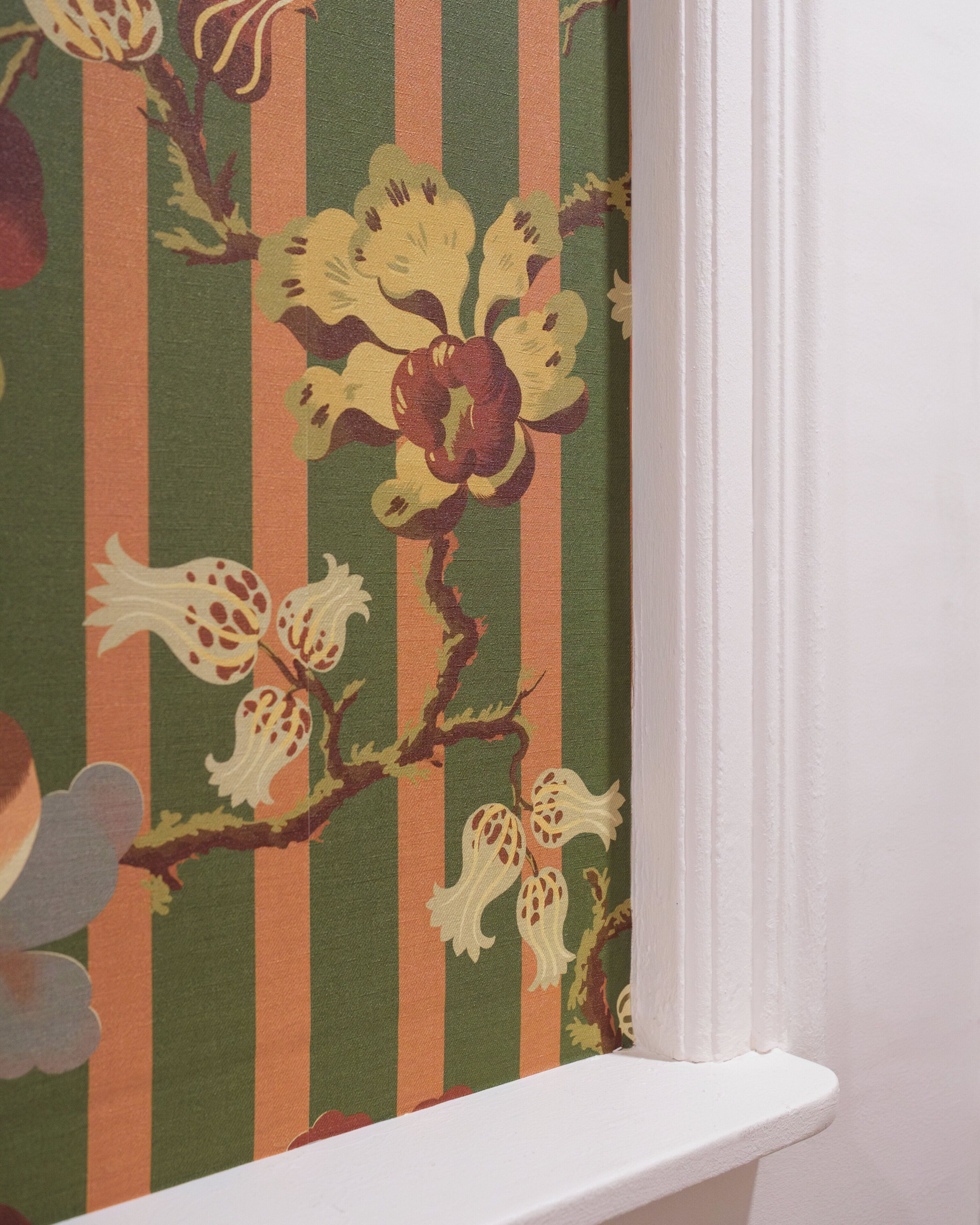 A corner of a room with a striped wallpaper featuring floral patterns.