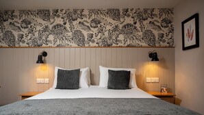 A hotel room with a large bed, two bedside lamps, a floral-patterned wallpaper, and a framed artwork on the wall. - The Cedars Inn by Greene King Inns (Barnstaple)