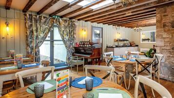 A dining area with wooden tables, chairs, and a piano.