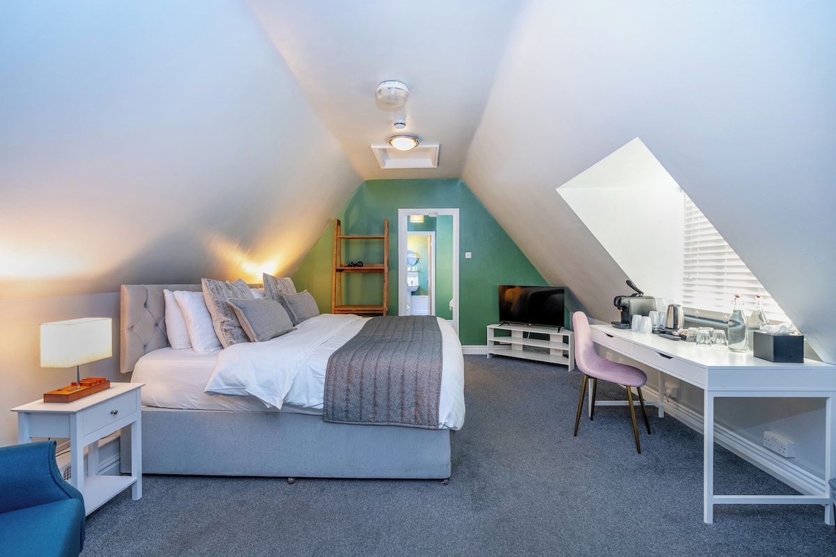 Un dormitorio con cama, escritorio, silla y televisor.