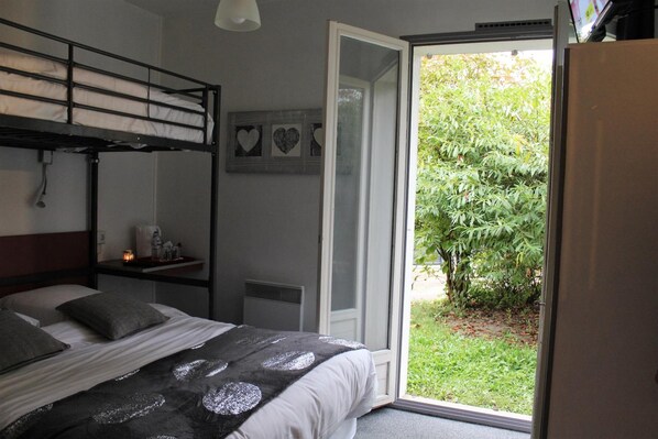 Un dormitorio con literas, una ventana y vistas a zonas verdes.