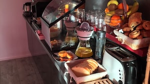 Un bufé de desayuno con diversos alimentos, una máquina de café y un tostador.