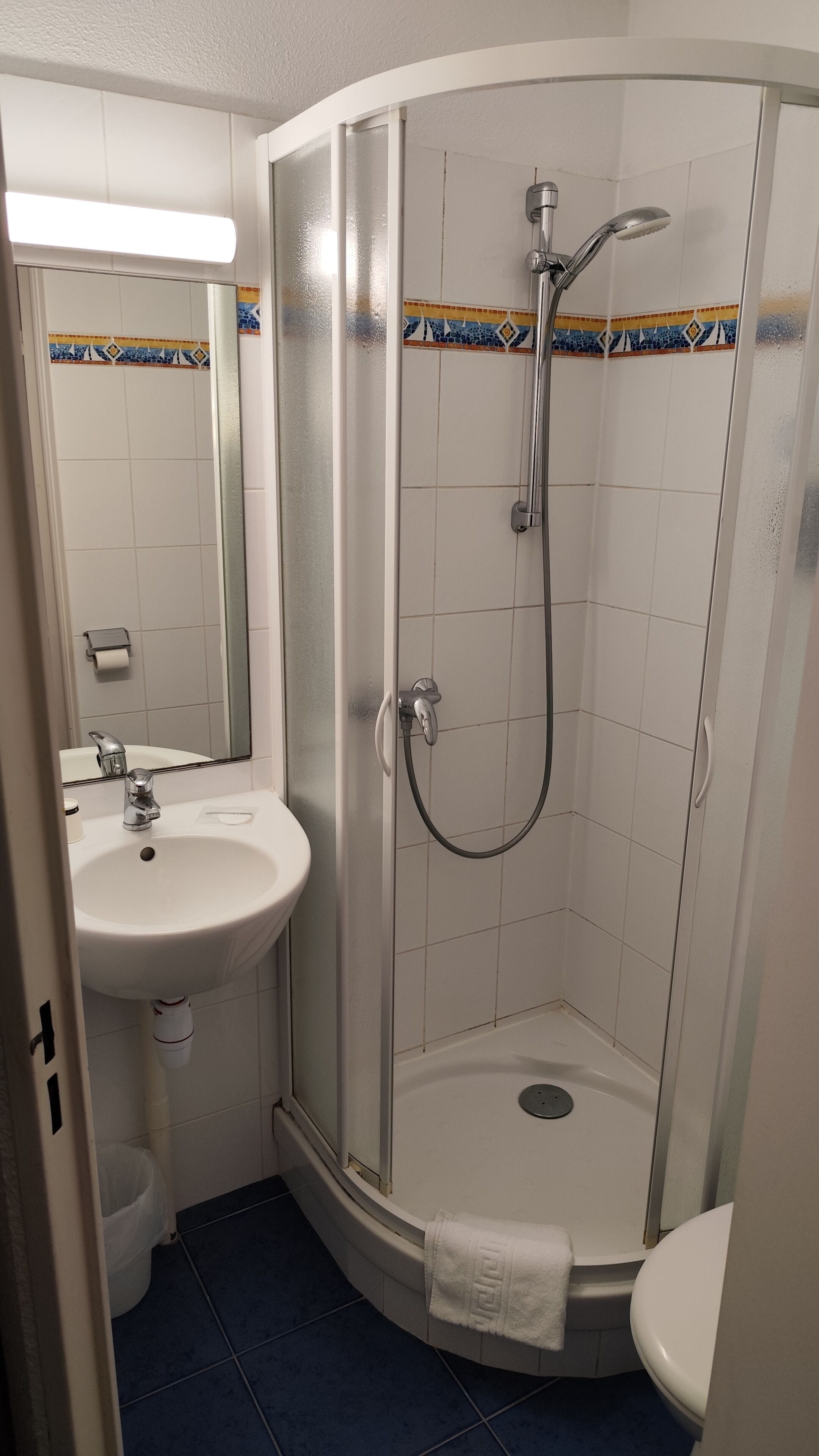 Ein Badezimmer mit einer Duschkabine, einem Waschbecken und einer Toilette.