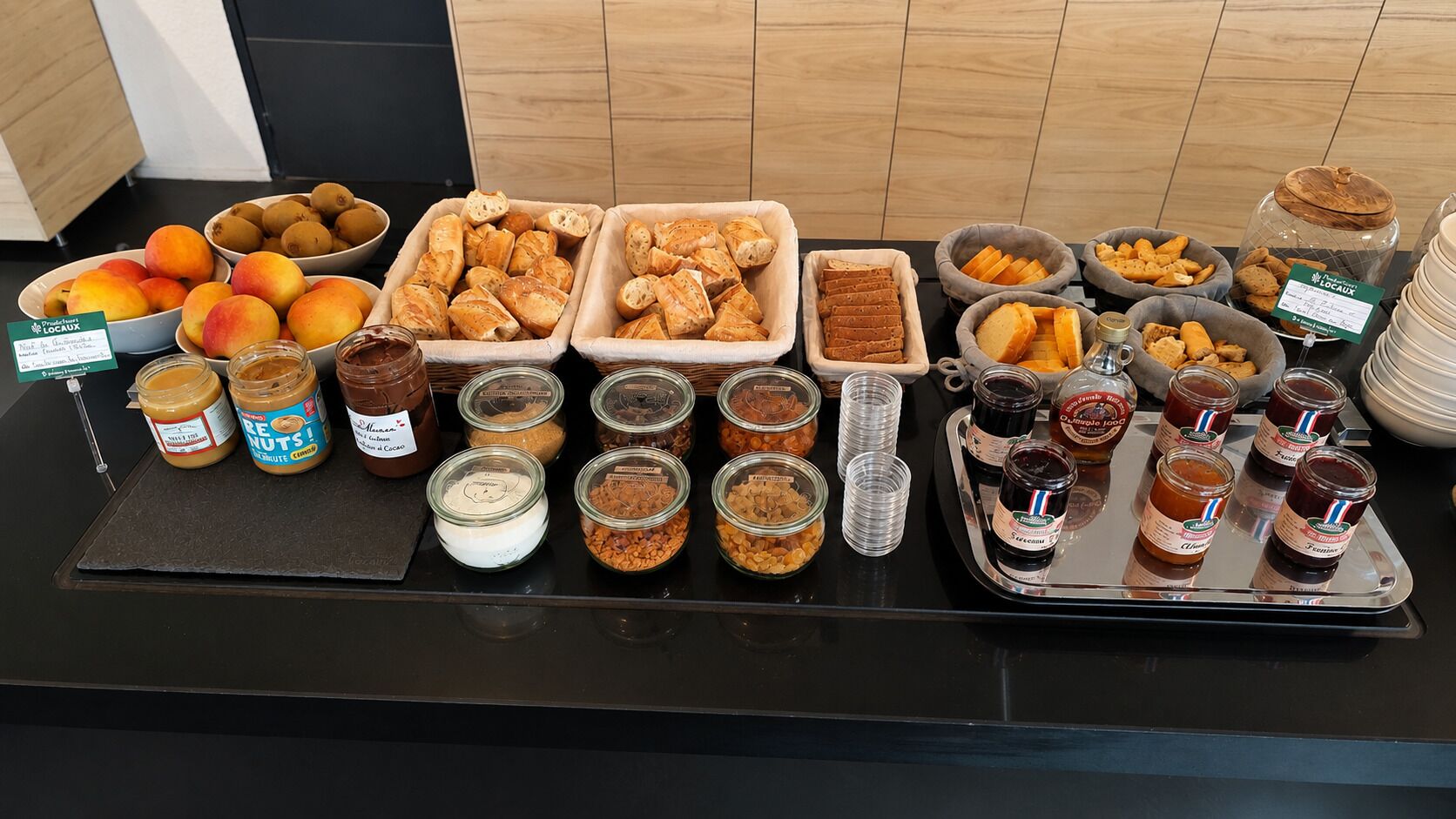 Taula de buffet amb diversos aliments, com fruita, pa i condiments.