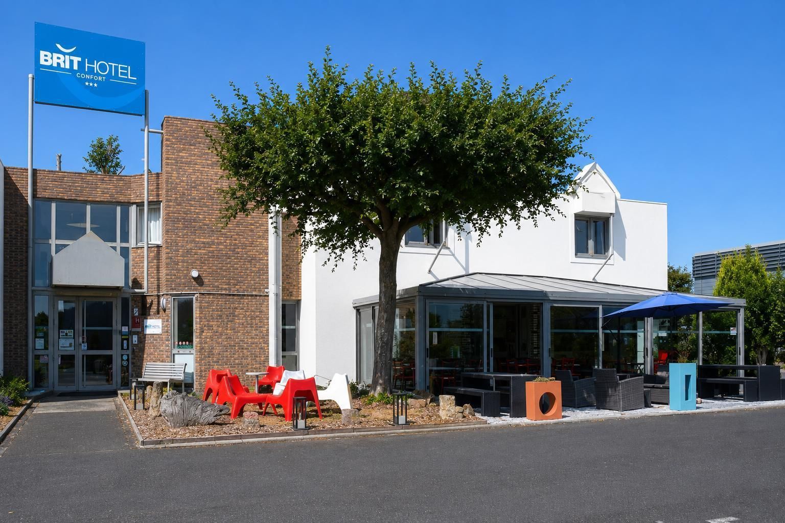 Un hotel con un letrero llamativo, un área de estar al aire libre y un patio cubierto.
