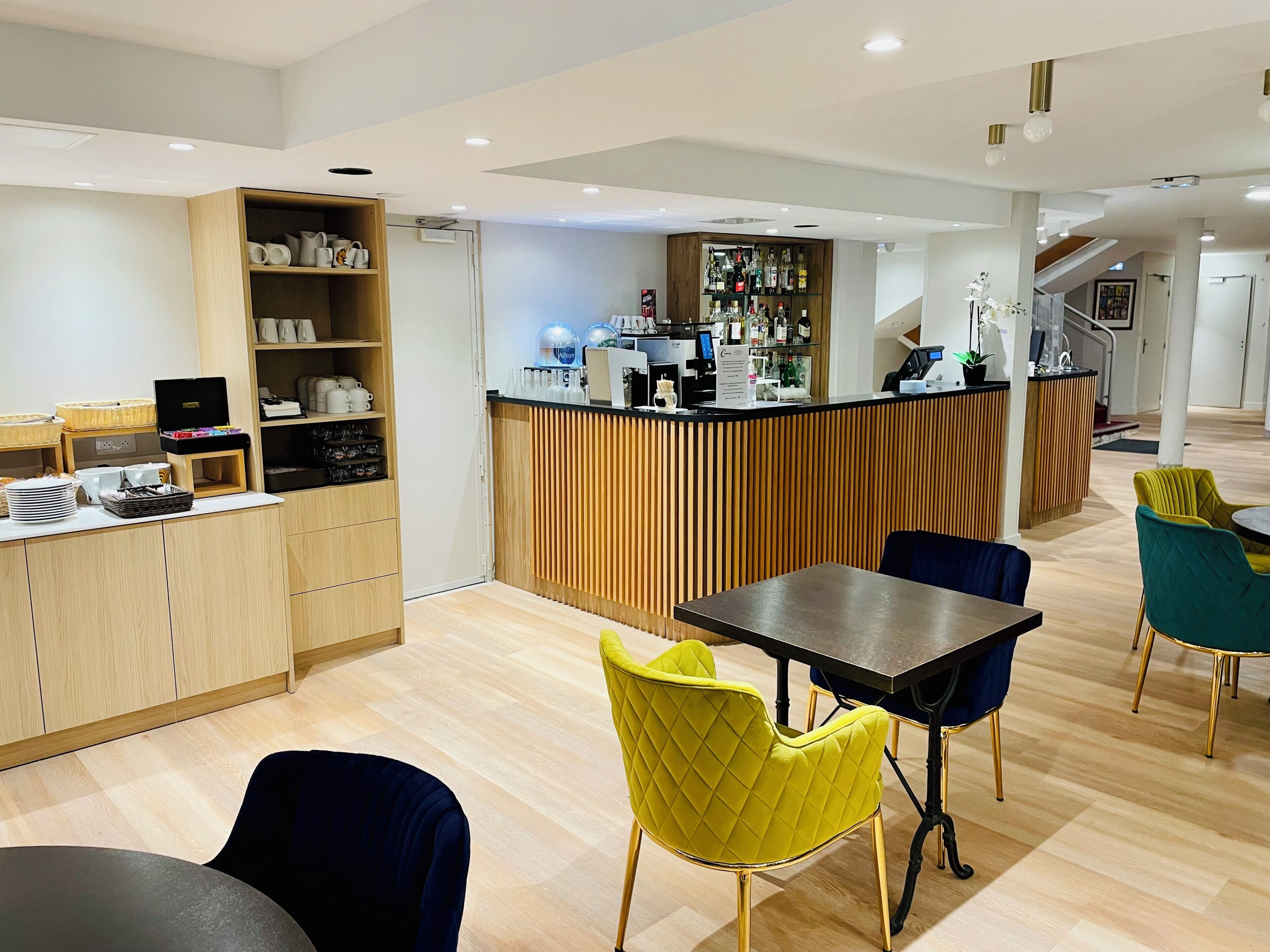 Un moderno vestíbulo de hotel con mostrador de recepción, zona de estar y un bar.
