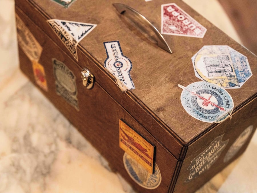 A wooden suitcase with various travel stickers and labels.