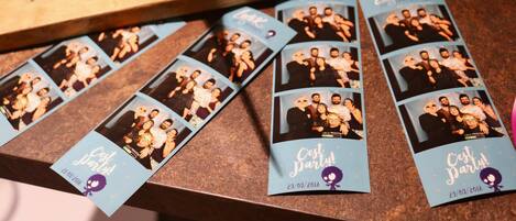 Un tavolo con diverse card di bomboniere blu raffiguranti foto di gruppo e la scritta