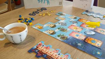 Una mesa con un juego de mesa, una taza de café y un extintor.