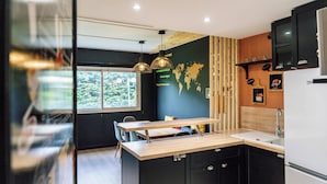 Een moderne keuken met een houten aanrecht, zwarte kastjes en een ingebouwde oven.