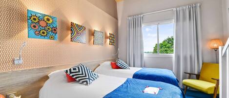 A hotel room with two beds, a wooden ceiling, a window with curtains, and artwork on the wall.