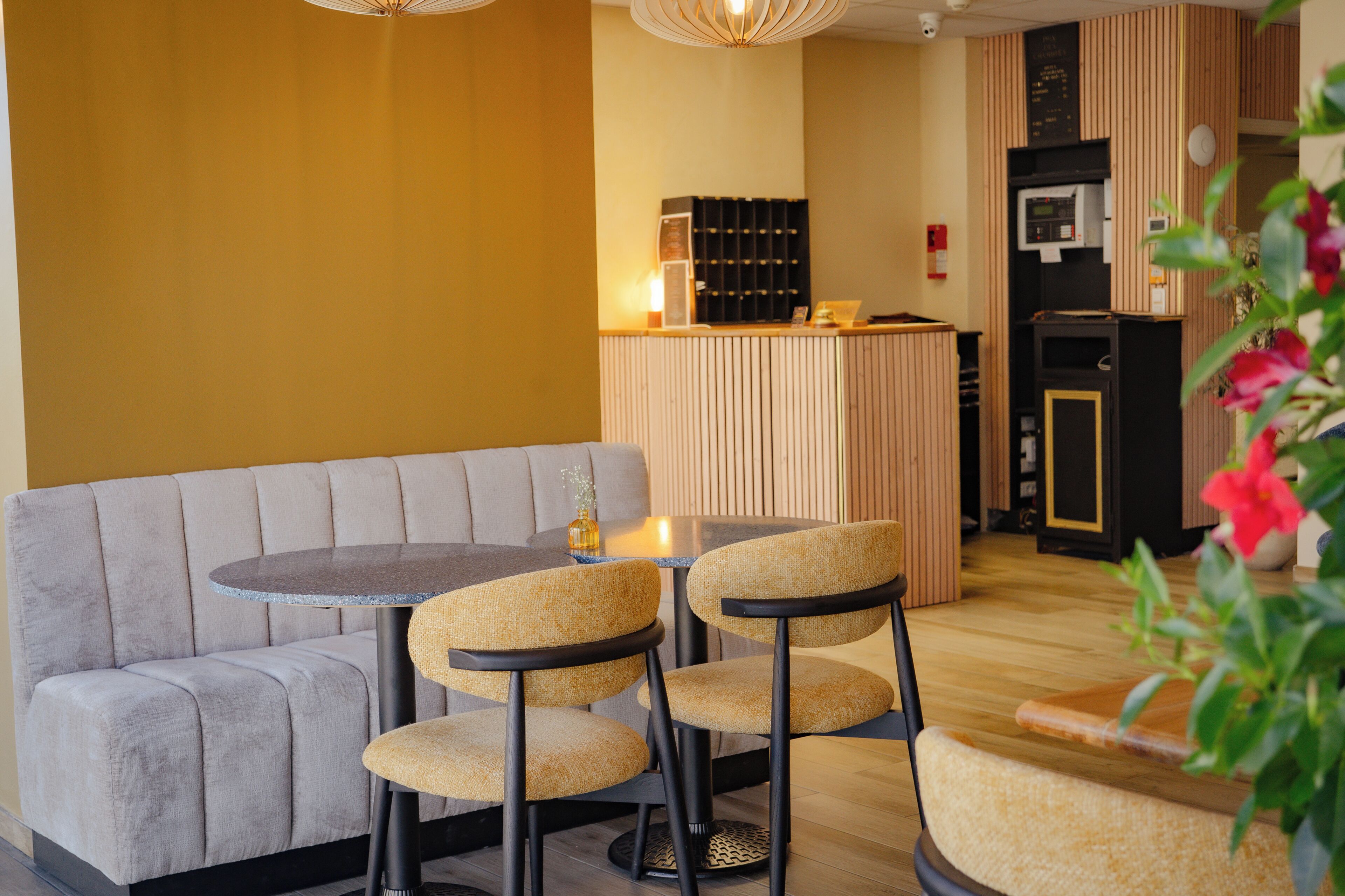 A modern interior with a sofa, round table, and chairs, a kitchen area, and a wooden counter.