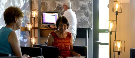 A modern interior with a stone wall, a digital screen, and multiple reading lamps.