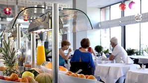 Un ricco buffet della colazione con frutta assortita e un erogatore di succo.