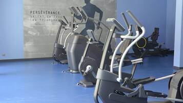A gym with stationary bikes and a motivational quote on the wall.