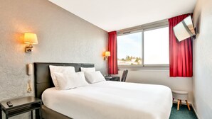 A hotel room with a large bed, two bedside lamps, a desk with a chair, a small stool, and a window with red curtains. - Hôtel Bristol Périgueux Centre (Périgueux)