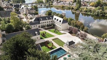 Un patio con piscina, rodeado de edificios y un río.