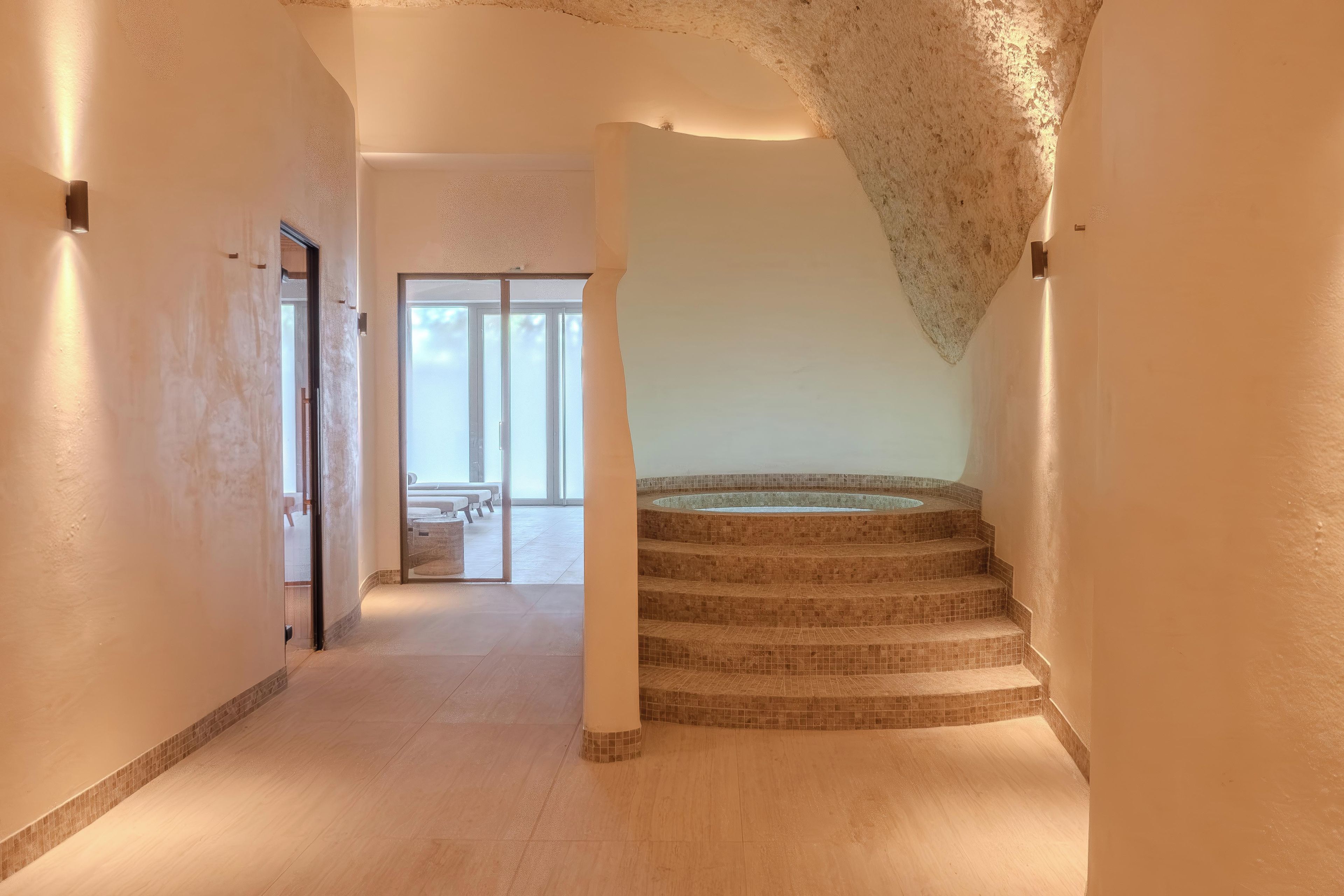 A modern interior with a spiral staircase leading to a balcony.