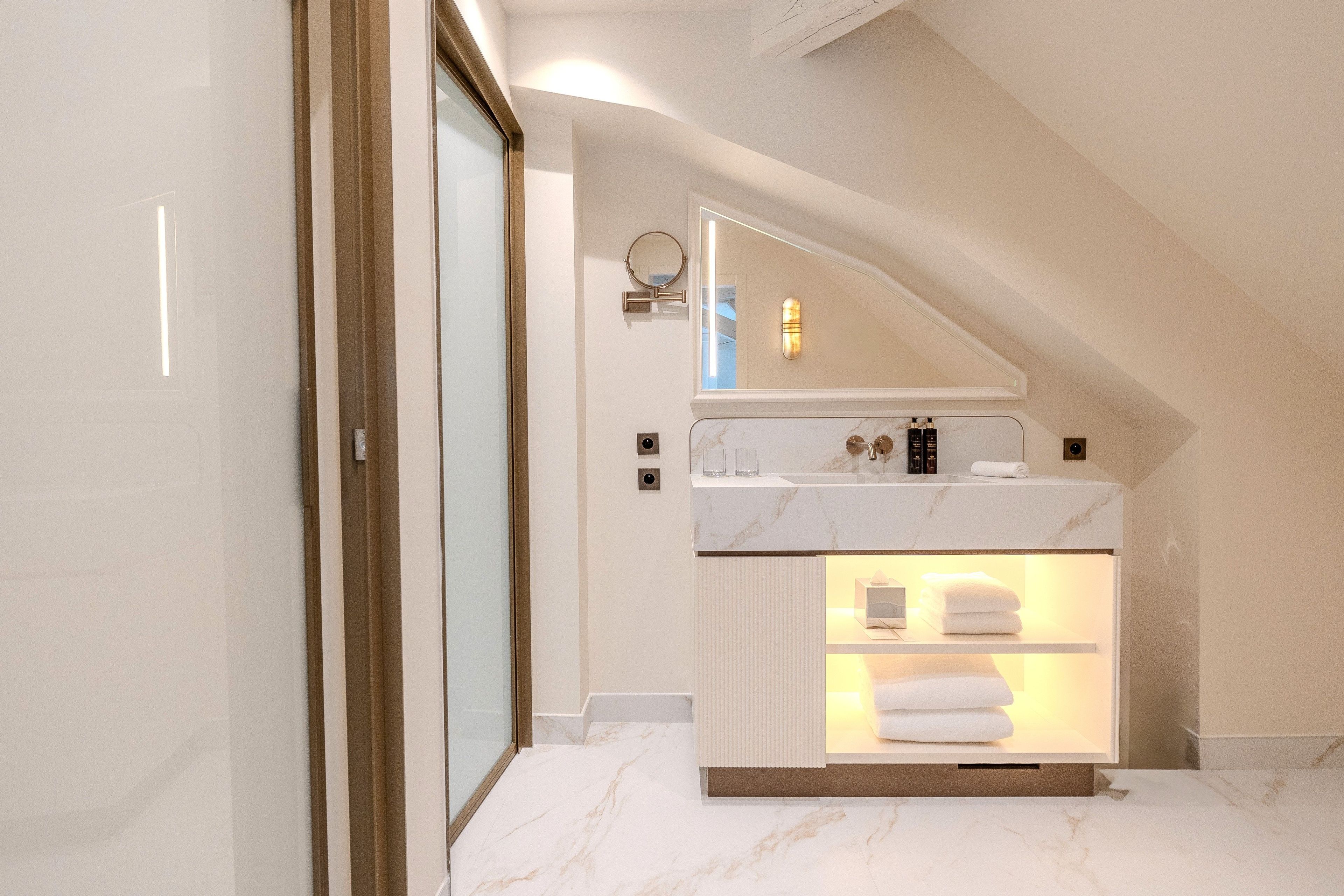 A modern bathroom with a marble countertop, a built-in shower, and a towel rack.