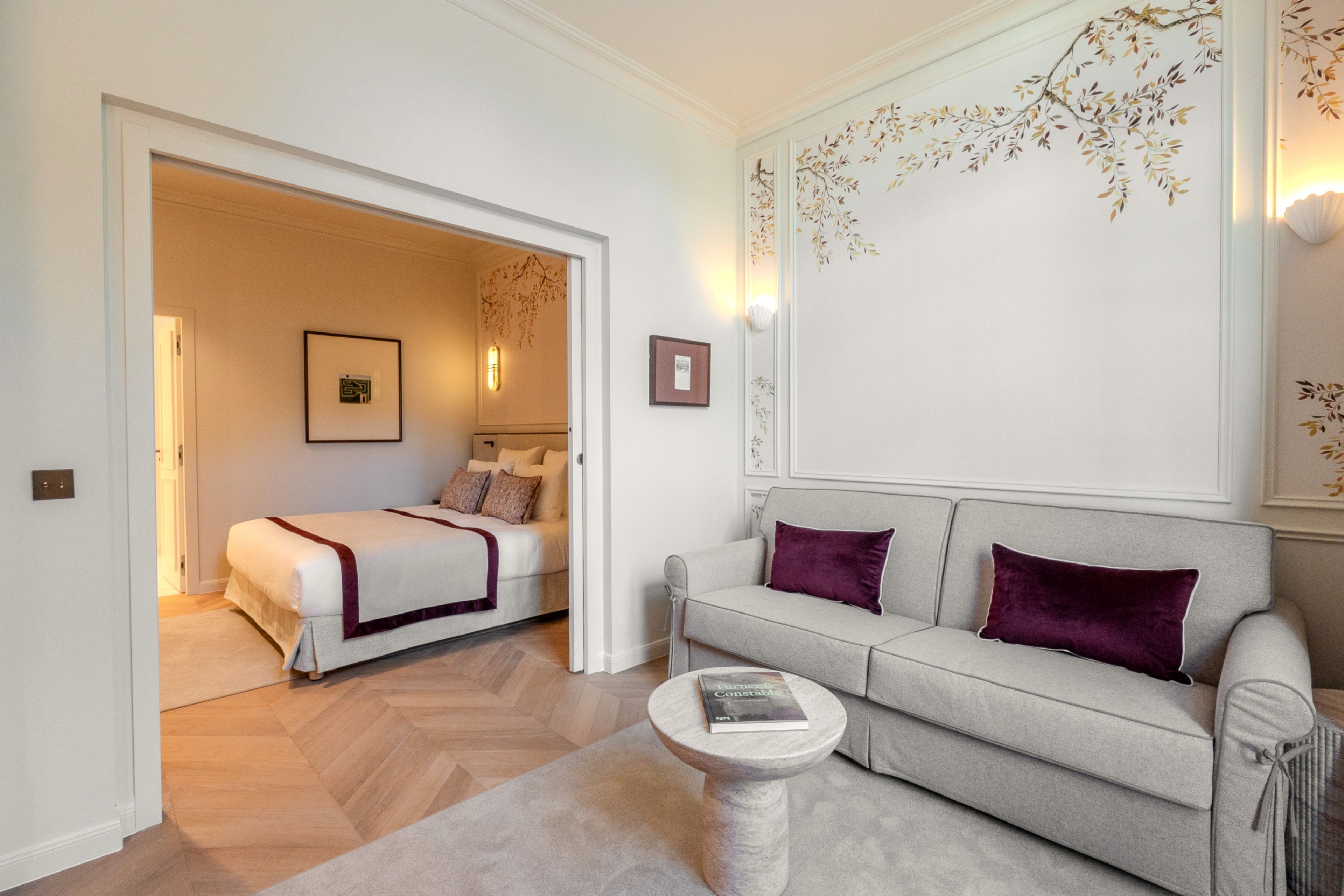 Una sala moderna con un sofá, una mesa de centro y una cama con cabecera.