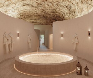 A spa with a circular hot tub, towels on hooks, and wall-mounted lights. - Relais d'Amboise - The Leading Hotels of the World (Amboise)