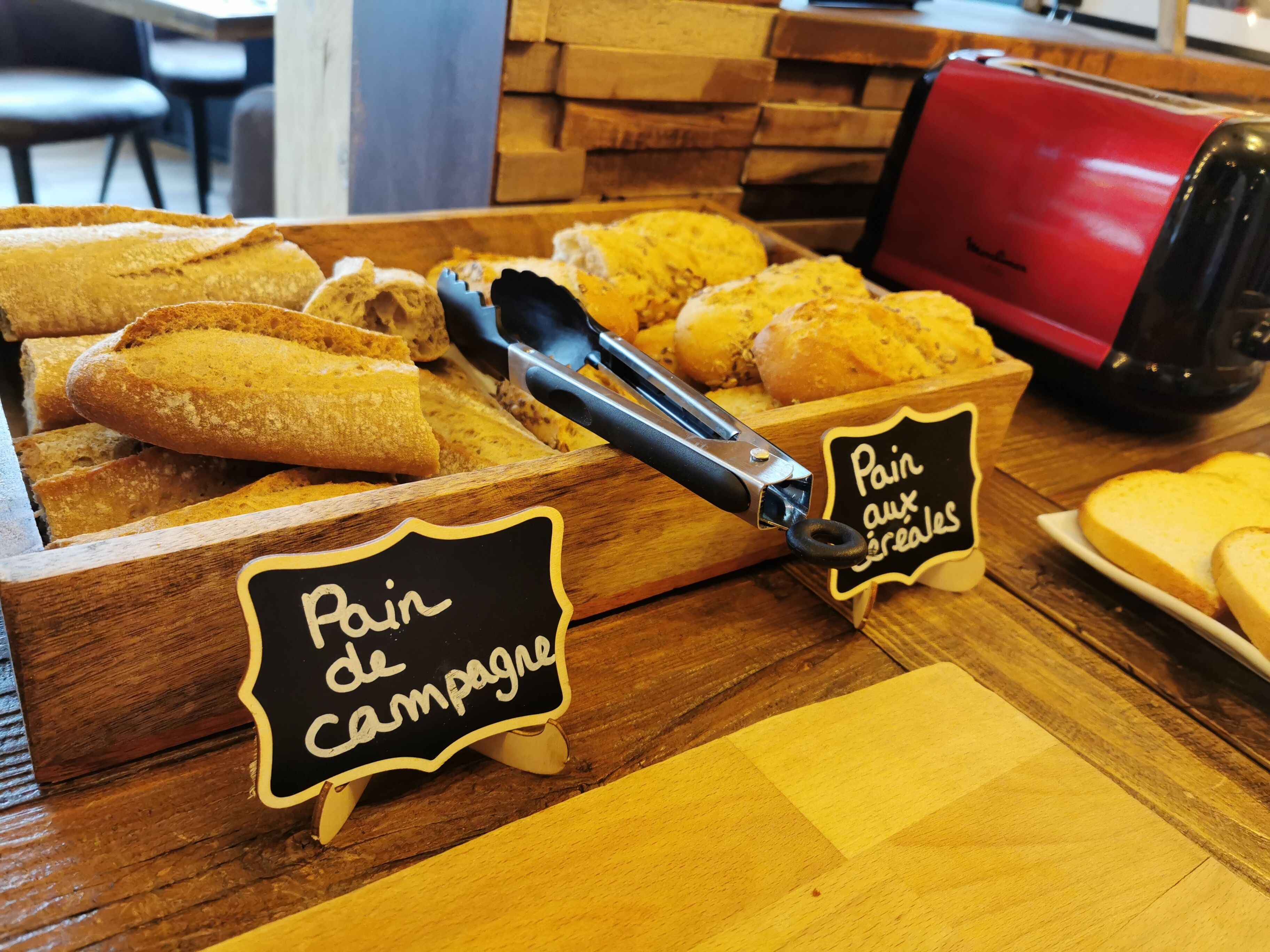 A bakery display with bread and a sign that reads "Pain de campagne".