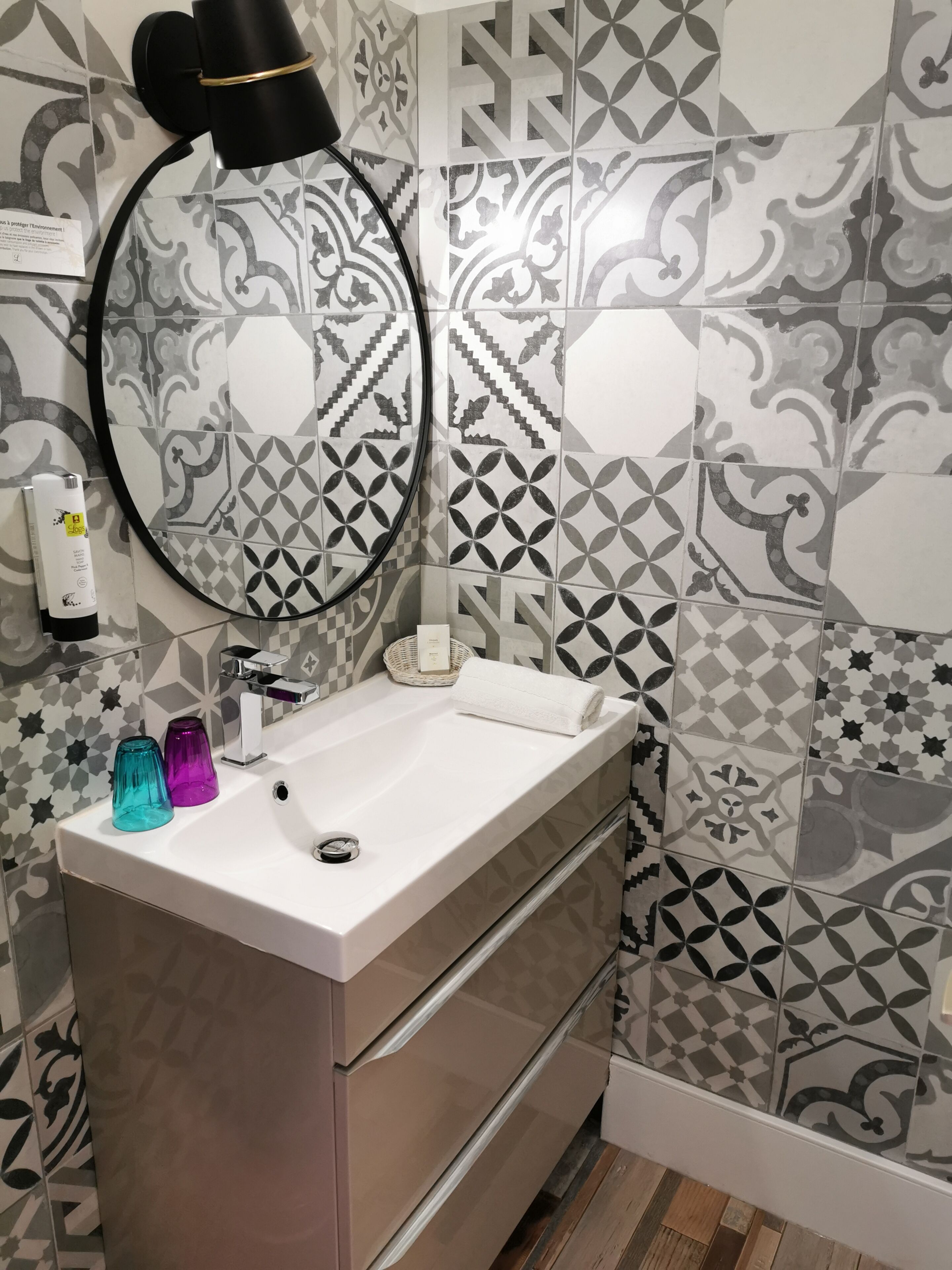 Une salle de bain avec un lavabo blanc, un miroir et une serviette.