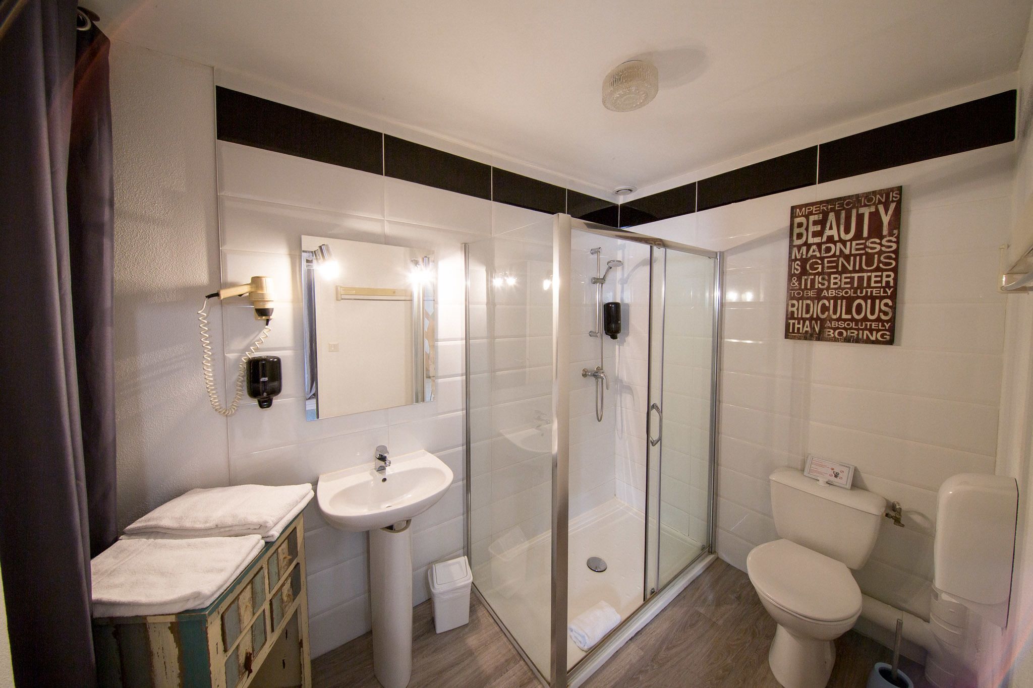 Un baño moderno con cabina de ducha de vidrio, lavamanos e inodoro.
