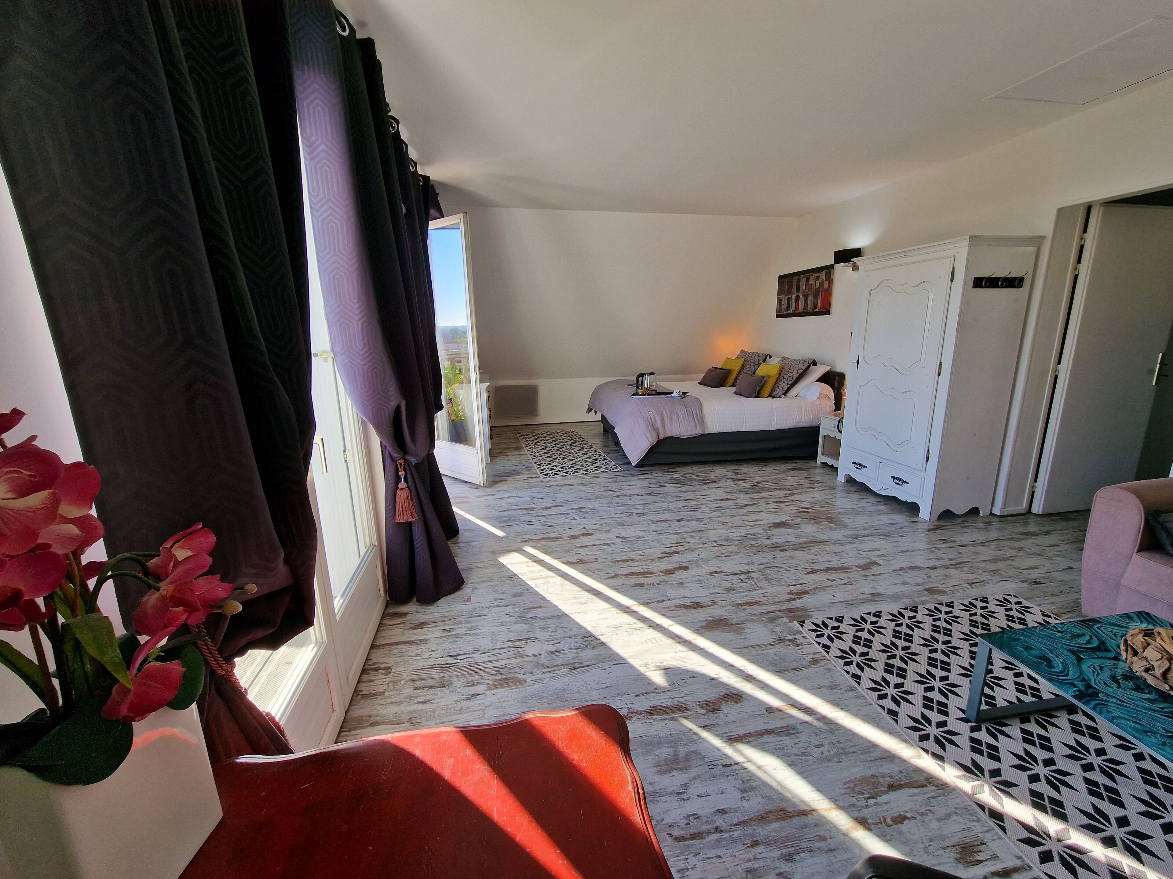 A room with a bed, a nightstand, a wardrobe, and a window with curtains.